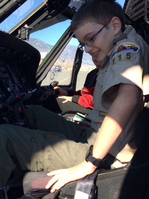 A scout sitting in the copilot seat of an Army Blackhawk helicopter